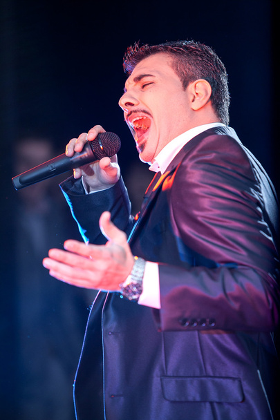 Macho-Mann singt in Mikrofon auf der Bühne - Foto, Bild
