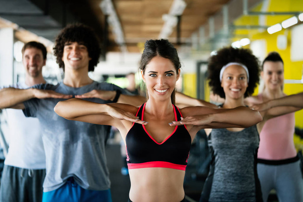 Beautiful fit people friends exercising together in gym - Foto, Imagem