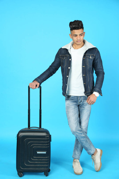 Φωτογραφία ενός έξυπνου αγοριού με βαλίτσα. Απομονωμένα σε λευκό φόντο. - Φωτογραφία, εικόνα