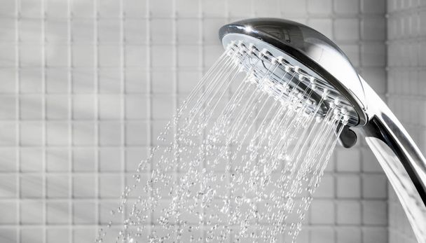 Sprcha hlava s tekoucí vodou v bílé koupelně - Fotografie, Obrázek