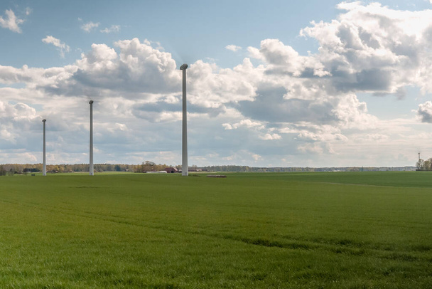green sown field with Wind turbines generating electricity. Spring Central Sweden. selective focus - Foto, imagen