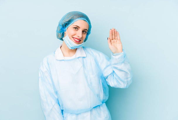 Jeune chirurgienne isolée souriante joyeuse montrant numéro cinq avec les doigts
. - Photo, image