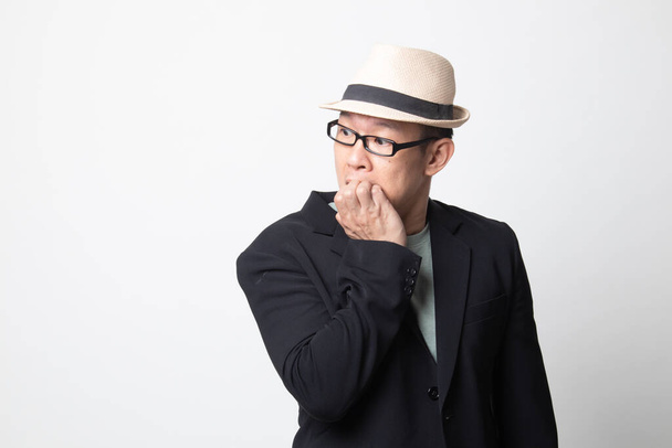 Unsure hesitant nervous adult asian man  biting his fingernails on white background - Фото, зображення