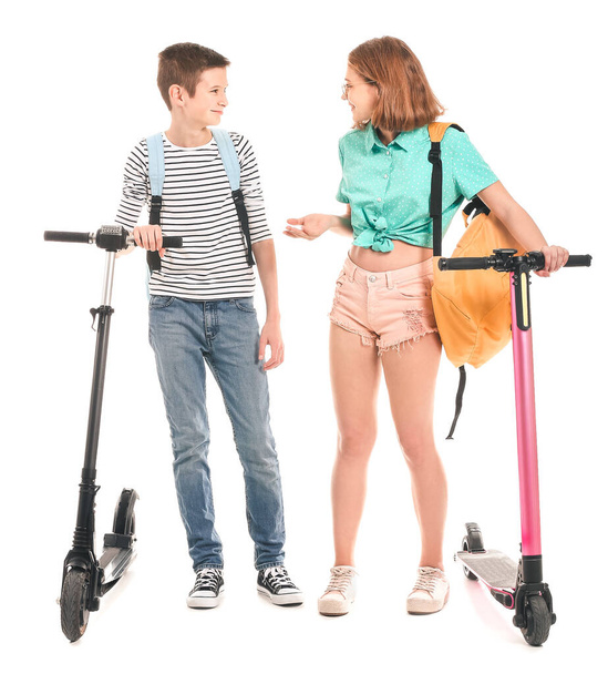 Active teenagers with kick scooters on white background - Фото, изображение
