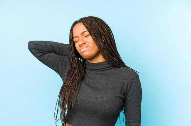 Mladá africká americká žena izolované na modrém pozadí trpí bolestí krku v důsledku sedavý životní styl. - Fotografie, Obrázek