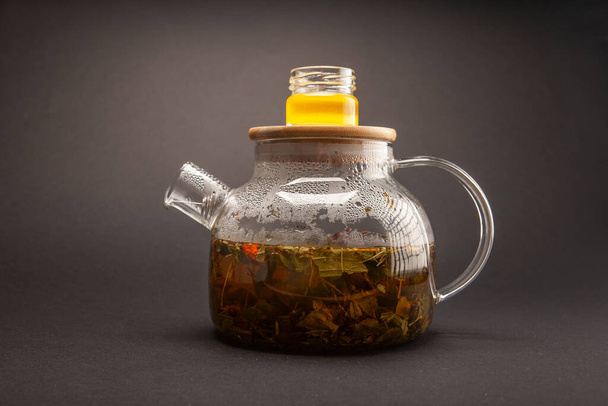 brewed hot tea in a glass teapot on a gray background - Fotó, kép