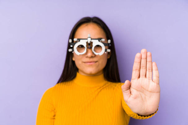 Youn indiaanse vrouw met optometrie bril staan met uitgestrekte hand tonen stop teken, voorkomen dat u. - Foto, afbeelding