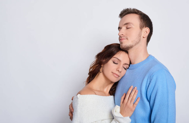 Image of a tender attractive millennial couple in love closed their eyes, romantic relationship, young wife and family spouse, concept image of love and dating. Copy space. - Foto, imagen