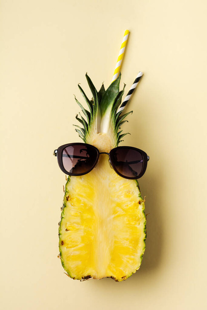 Fresh pineapple cut in two part, notebook or sketchbook and sunglasses on yellow background. Summer concept. Creative flat lay with copy space. Top view. - Foto, immagini