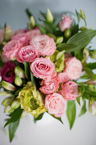 Bouquet lumineux avec roses, eustomes et alstroemeria en vase blanc. Bouquet sur fond bleu doux
 - Photo, image