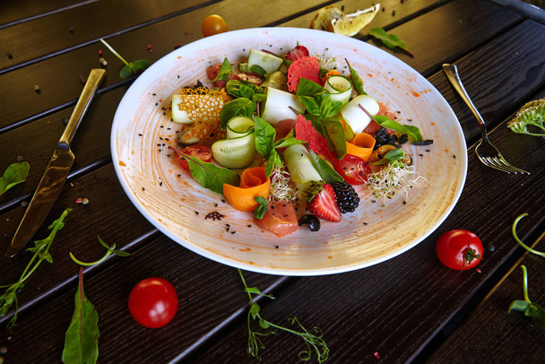 salad on a white plate of fresh fruits berries and vegetables - 写真・画像