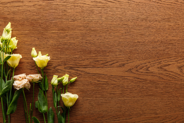top view of blooming eustoma flowers on wooden background - Photo, Image
