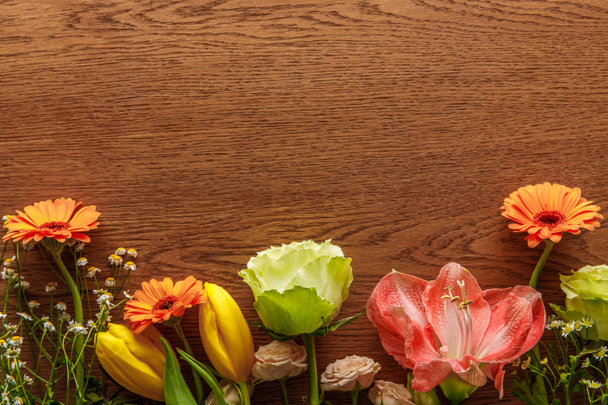 top view of blooming colorful spring flowers on wooden background - Φωτογραφία, εικόνα
