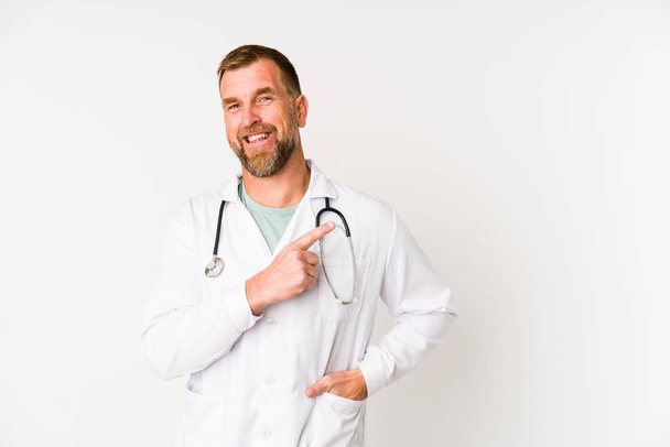 Senior doctor man isoliert auf weißem Hintergrund lächelnd und zur Seite zeigend, zeigt etwas auf Leerstelle. - Foto, Bild
