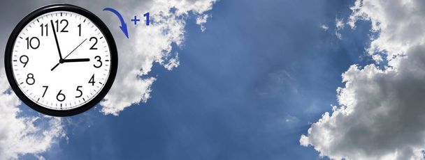 Daylight Saving Time Блакитне небо з білими хмарами і годинником. Поверніть час вперед (+ 1h). - Фото, зображення