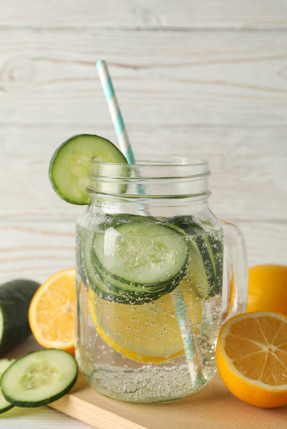 Skleněná sklenice okurkové vody, plátky a citrony na dřevěném pozadí, zblízka - Fotografie, Obrázek