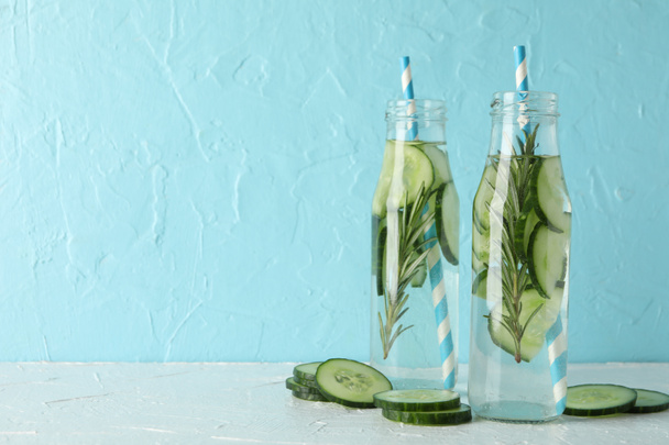 Composição com garrafas de água de pepino contra fundo azul, espaço para texto
 - Foto, Imagem