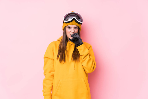 Joven esquiadora caucásica aislada mordiendo las uñas, nerviosa y muy ansiosa
. - Foto, Imagen