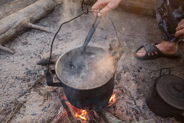 Hombre cocinar algo de comida en el campamento de jugadores de bolos
 - Foto, Imagen