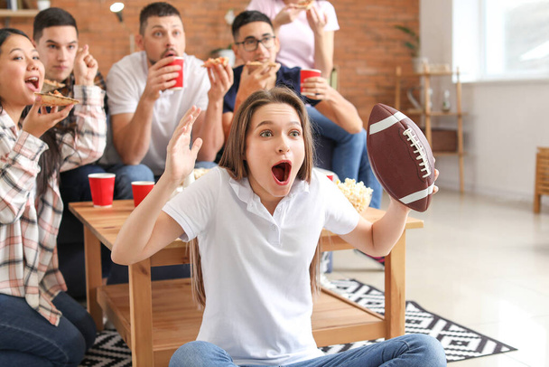 Young woman with friends watching rugby on TV - Photo, Image