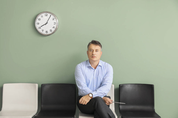 Ώριμος άντρας περιμένει συνέντευξη για δουλειά σε εσωτερικούς χώρους - Φωτογραφία, εικόνα
