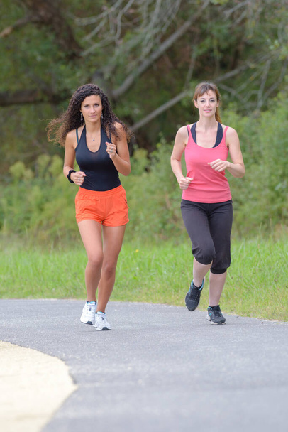 2 friends are jogging outdoor - Фото, изображение