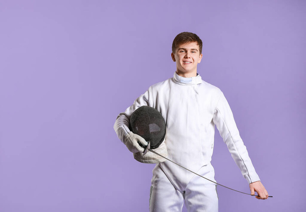 Young male fencer on color background - Photo, Image