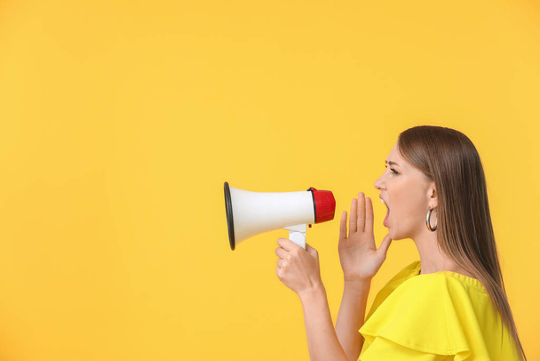 Young woman with megaphone on color background - Photo, Image