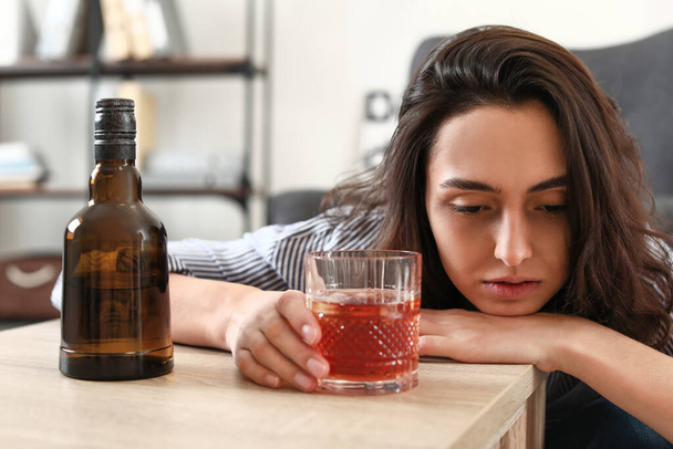 自宅でコニャックを飲む女性。アルコール依存症の概念 - 写真・画像