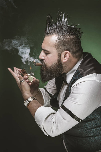 Hombre con barba encendiendo un cigarro
.  - Foto, imagen