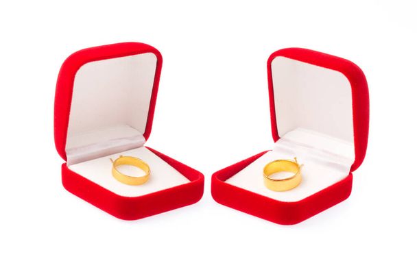 Золоті кільця на червоній оксамитовій коробці ізольовані на білому тлі
 - Фото, зображення