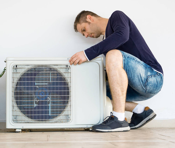 Mannelijke technicus installeren airconditioningsysteem. - Foto, afbeelding