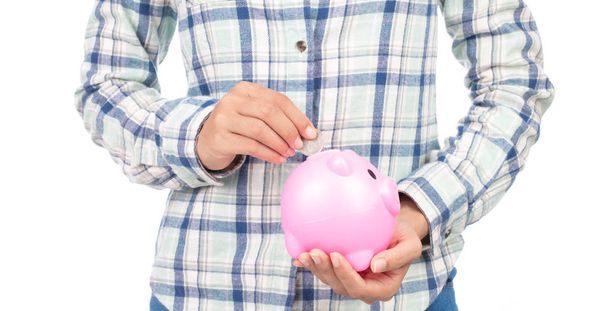 Portrait of girl in plaid shirt holding a piggybank isolated on white background. - Foto, Imagen