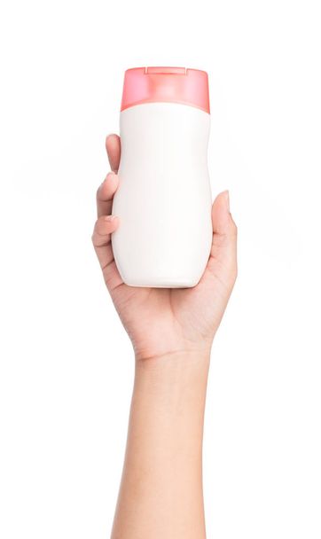 Mão segurando loção garrafa isolada no fundo branco
 - Foto, Imagem