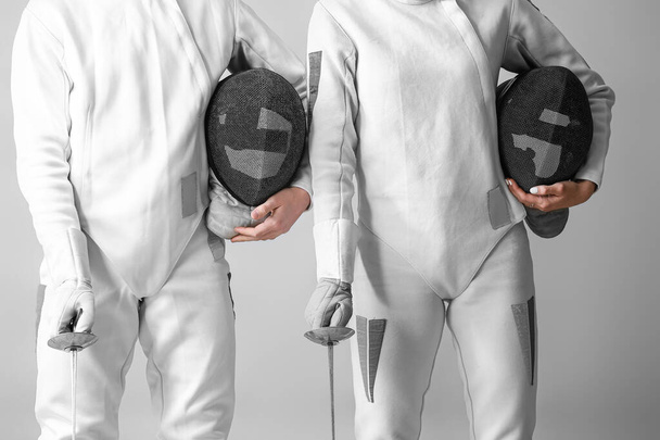 Young fencers on light background - Photo, Image