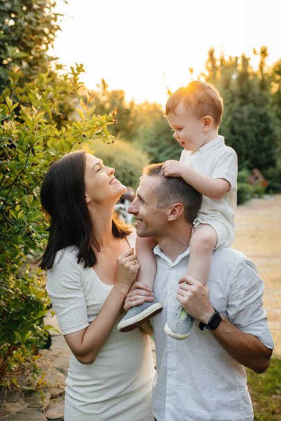 Happy family with their son walking in the Park at sunset. Happiness. Love - 写真・画像