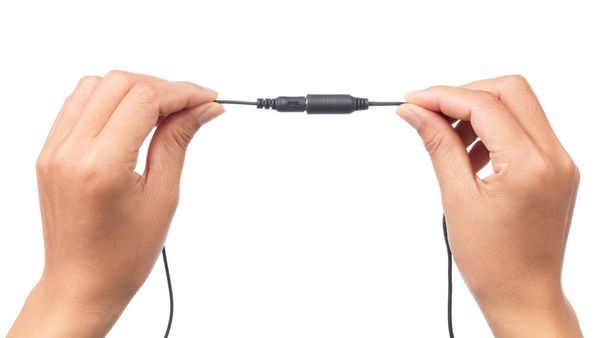mão segurando Audio Mini Jack Cable para microfone isolado em fundo branco
 - Foto, Imagem