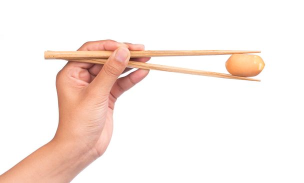 χέρι εκμετάλλευση λουκάνικο με chopstick απομονώνονται σε λευκό φόντο - Φωτογραφία, εικόνα