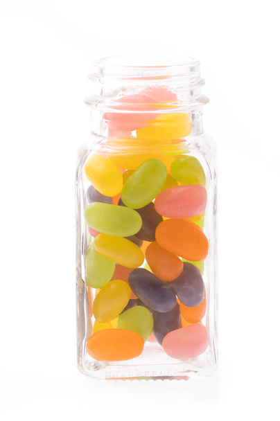 Gelee-Bohnen-Bonbons auf Glasflasche isoliert auf weißem Hintergrund - Foto, Bild