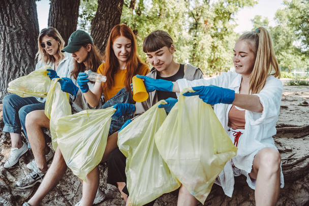 Grupo de activistas amigos recogiendo residuos plásticos en el parque. Conservación ambiental
. - Foto, Imagen