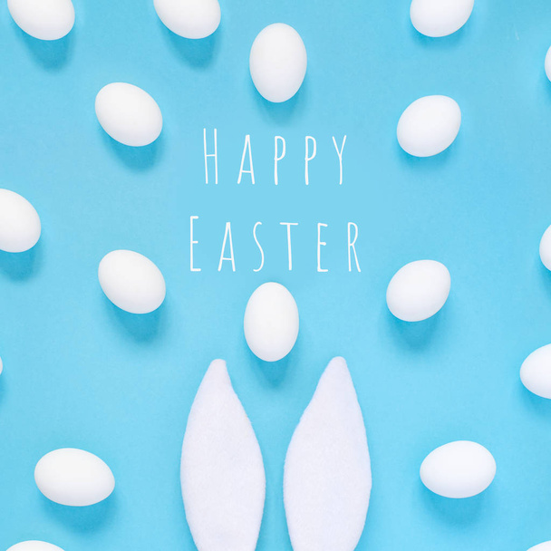 Easter concept. Rabbit ears and white eggs. On a blue background. - Foto, immagini