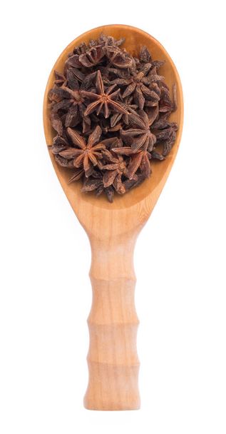 Αστέρι γλυκάνισο σε ξύλινη κουτάλα απομονώνονται σε λευκό φόντο - Φωτογραφία, εικόνα