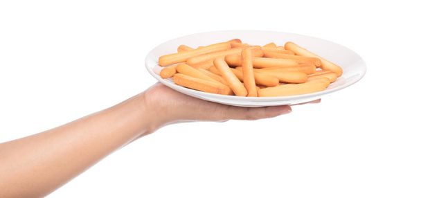 Hand hält Teller mit knusprigem Stroh auf weißem Hintergrund. Keks klebt isoliert auf weißem Hintergrund - Foto, Bild