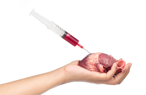 Blutspritze zur Injektion mit rohem Herzen an der Hand isoliert auf weißem Hintergrund - Foto, Bild