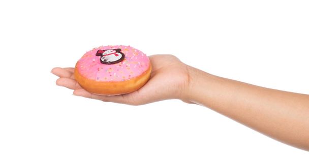 Hand hält Donut Schneemannmuster isoliert auf weißem Hintergrund. - Foto, Bild