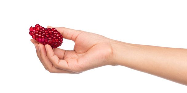 Hand hält Granatapfelkern isoliert auf weißem Hintergrund - Foto, Bild