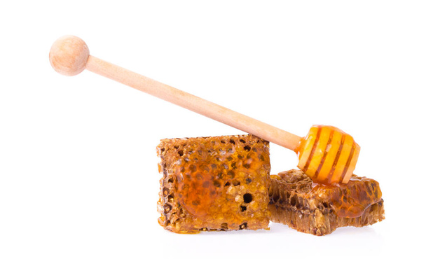 favos de mel com mergulhador de madeira para mel isolado no fundo branco
 - Foto, Imagem