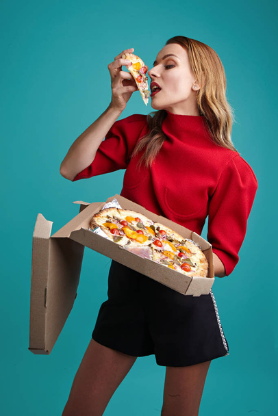 mujer rubia sostiene pizza en las manos
 - Foto, Imagen