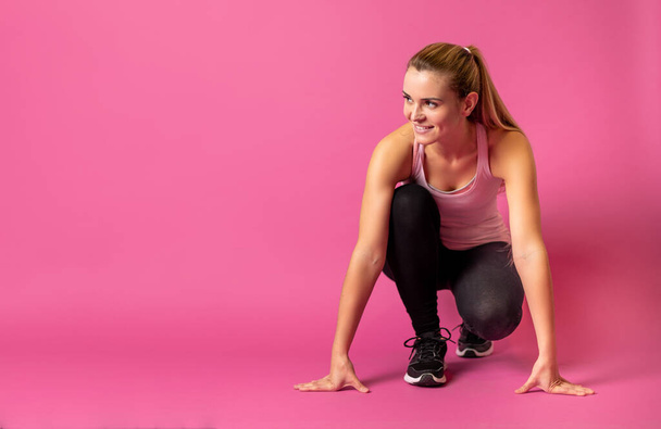 Fit woman on pink background at starting with copy space - Foto, Imagem