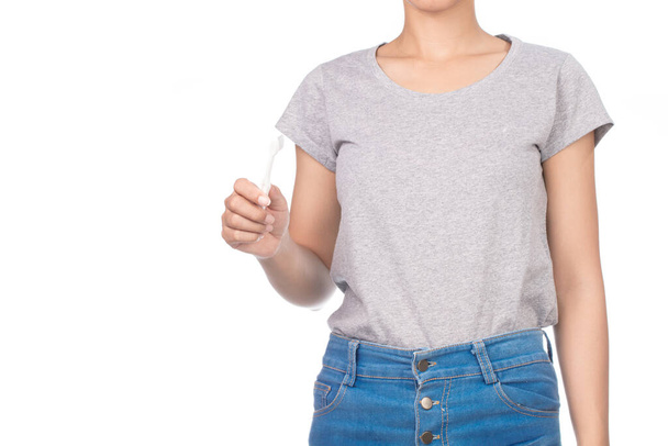 kobieta w białej szarej koszulce, dżinsy używać szczoteczki do zębów izolowane na białym tle. - Zdjęcie, obraz